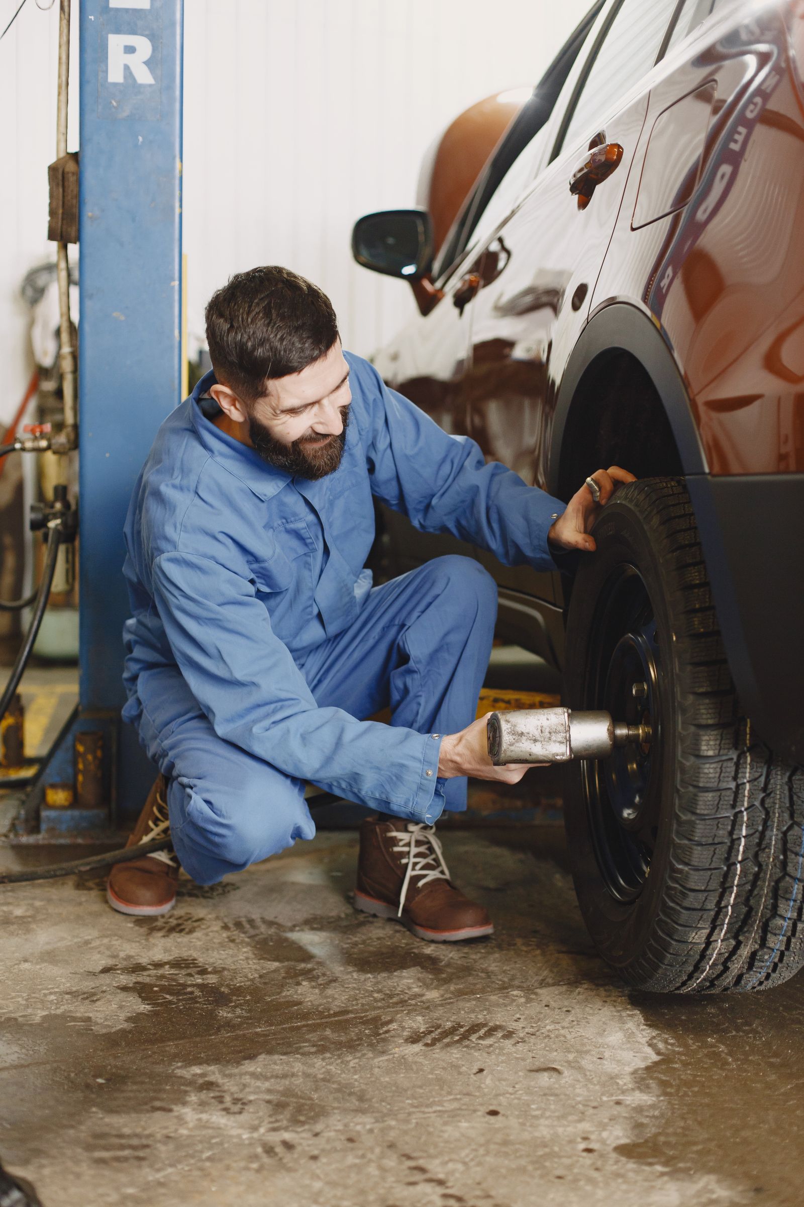 A technician kneeling to swap a tire