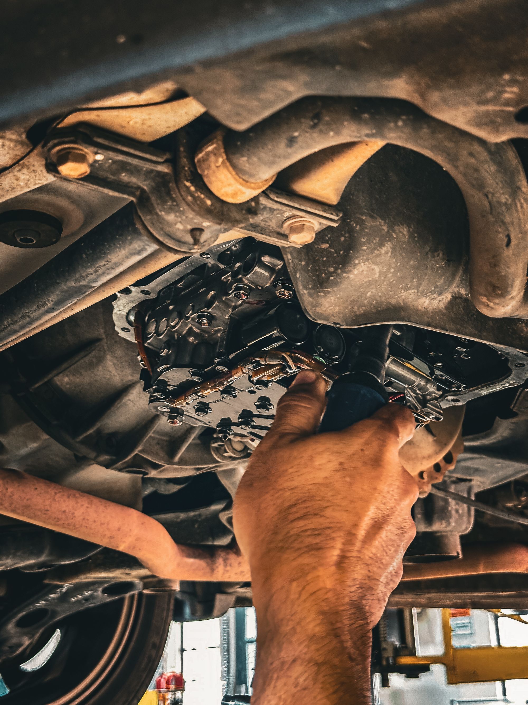 A technician working under a vehicle on a lift