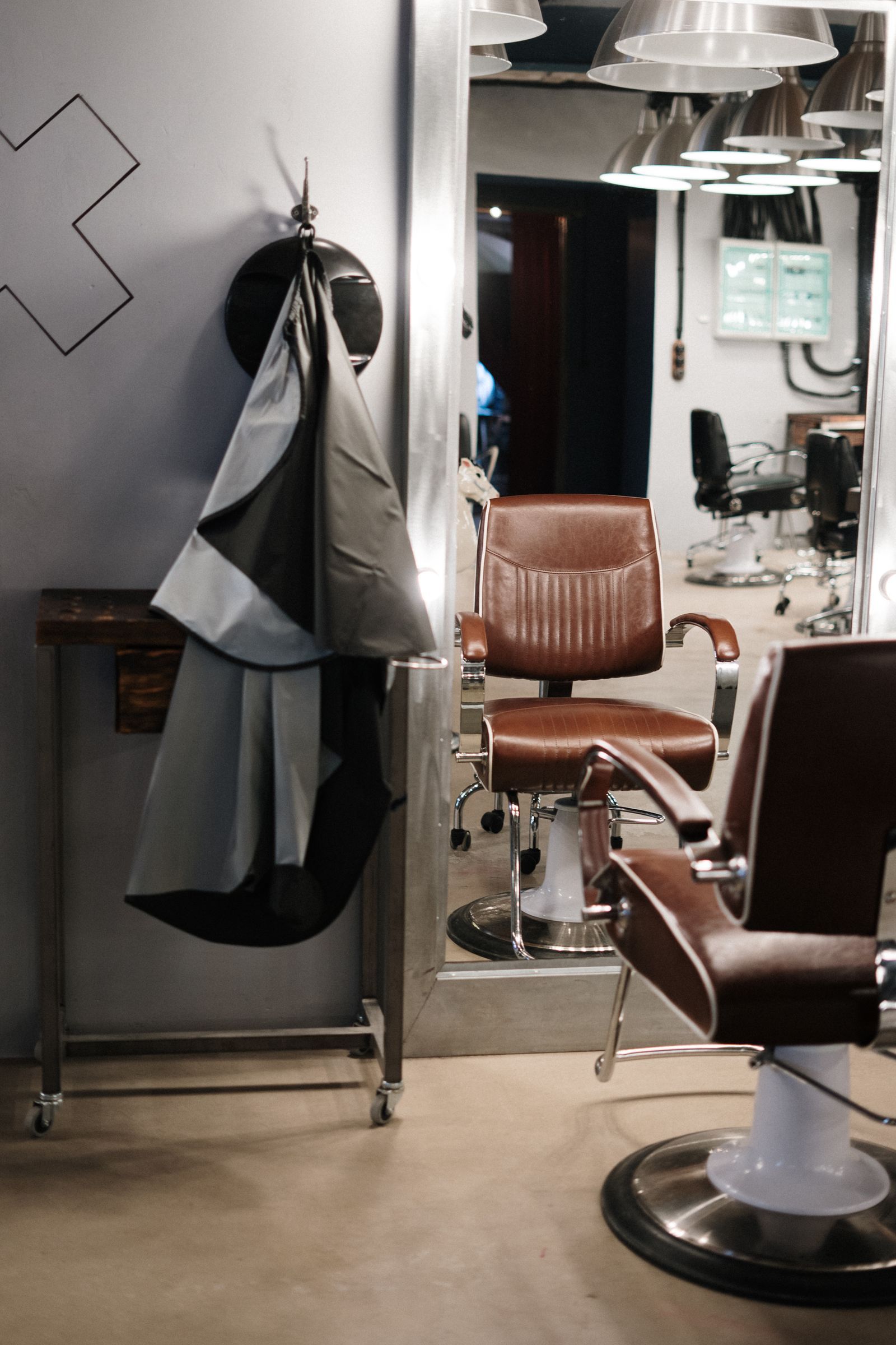 Barber chairs facing a long mirror in the shop