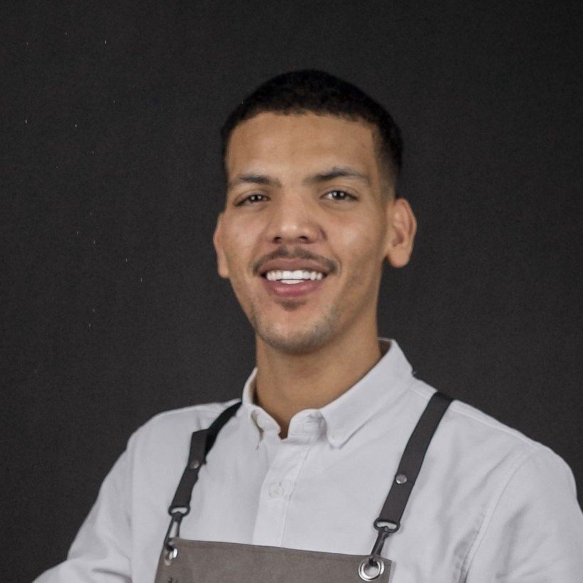 Imani Wells in a leather apron, smiling