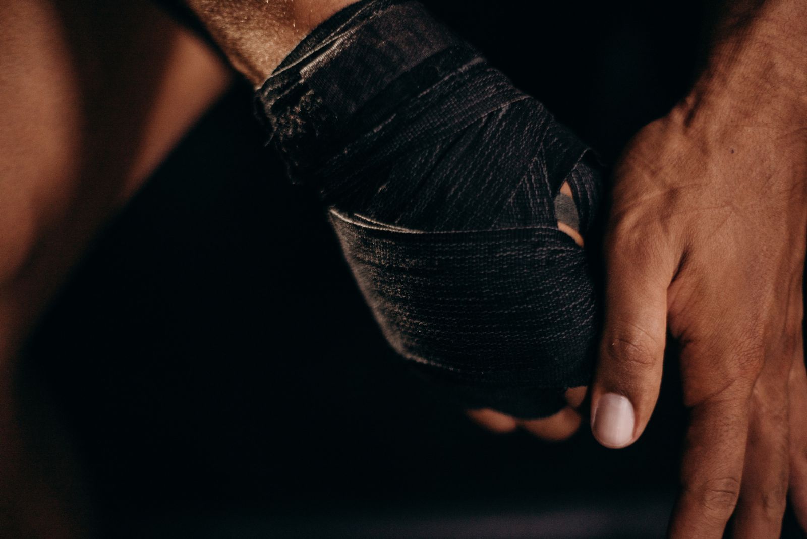 Close-up of a hand wrapped in black hand wraps