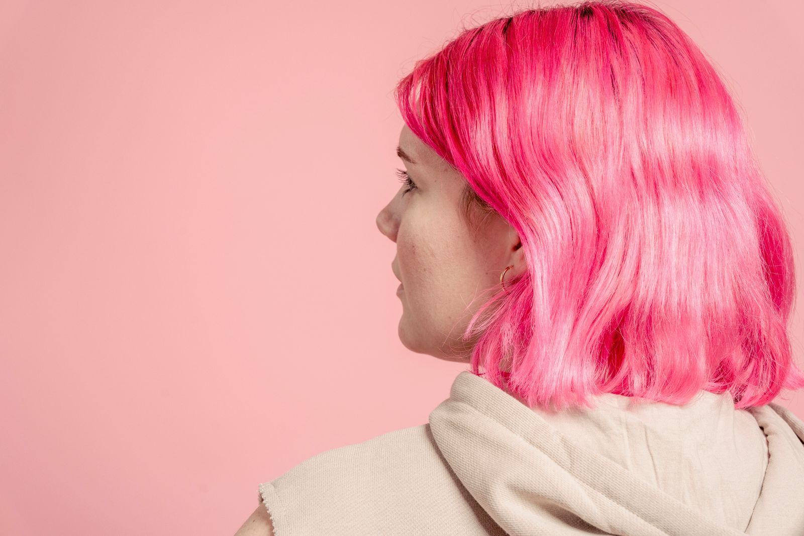 A pink bob seen from behind against a pink wall