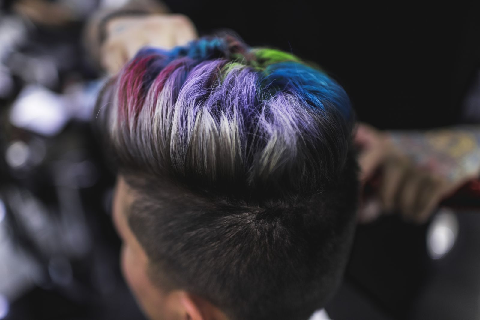 A short cut with purple, blue, and green on top of a dark undercut