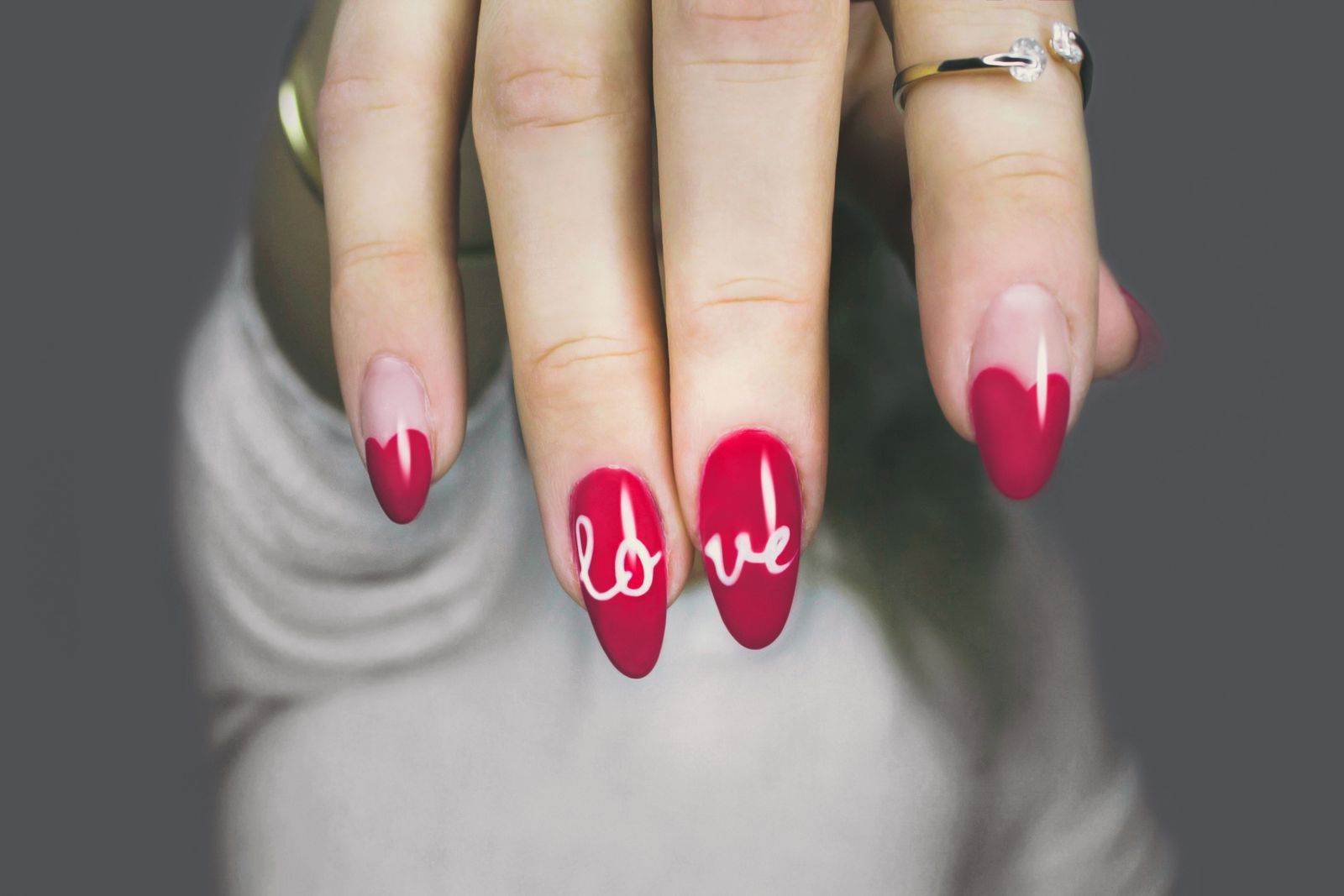 Red and nude nails with the word love written across two nails