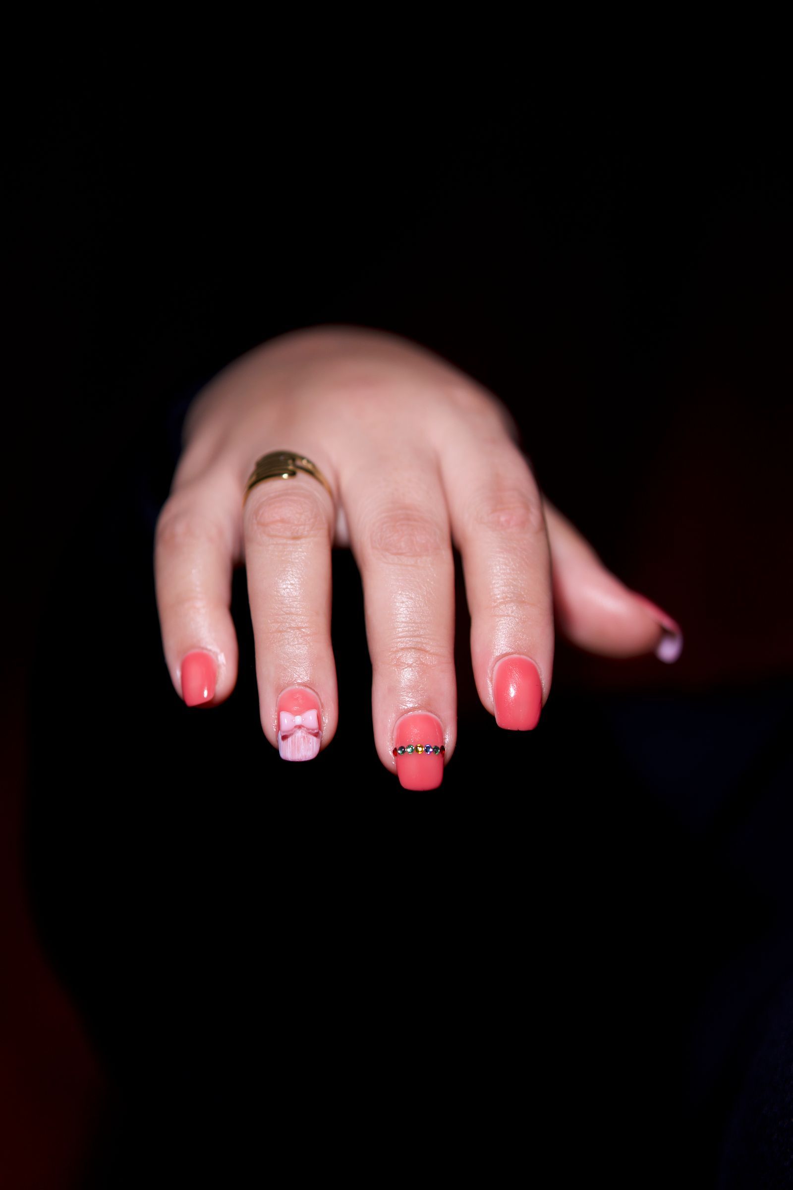 Short pink nails with tiny bows and gold accents