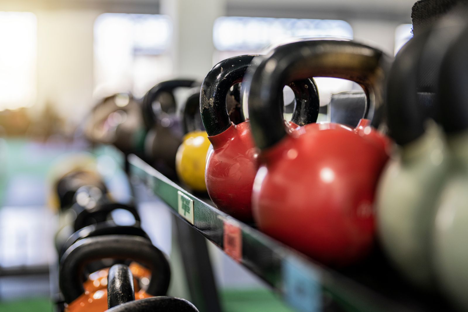 Kettlebells of different colours lined up on a rack