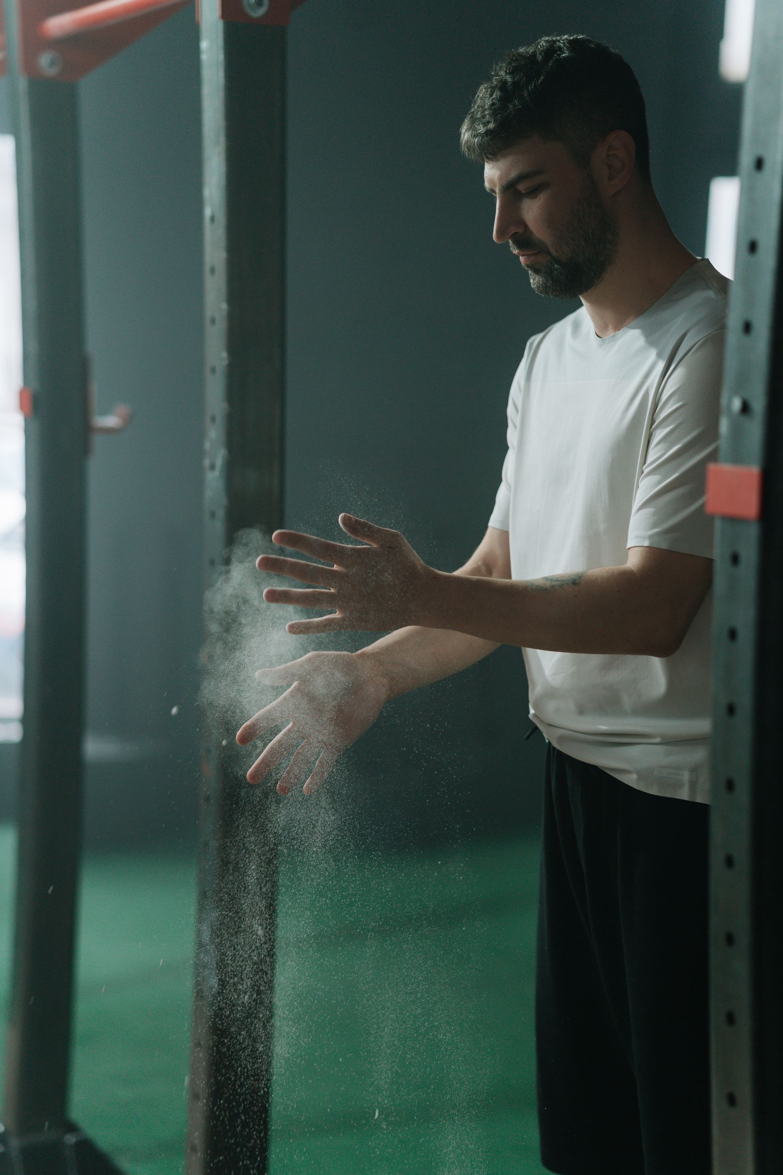 A member chalking his hands beside a squat rack