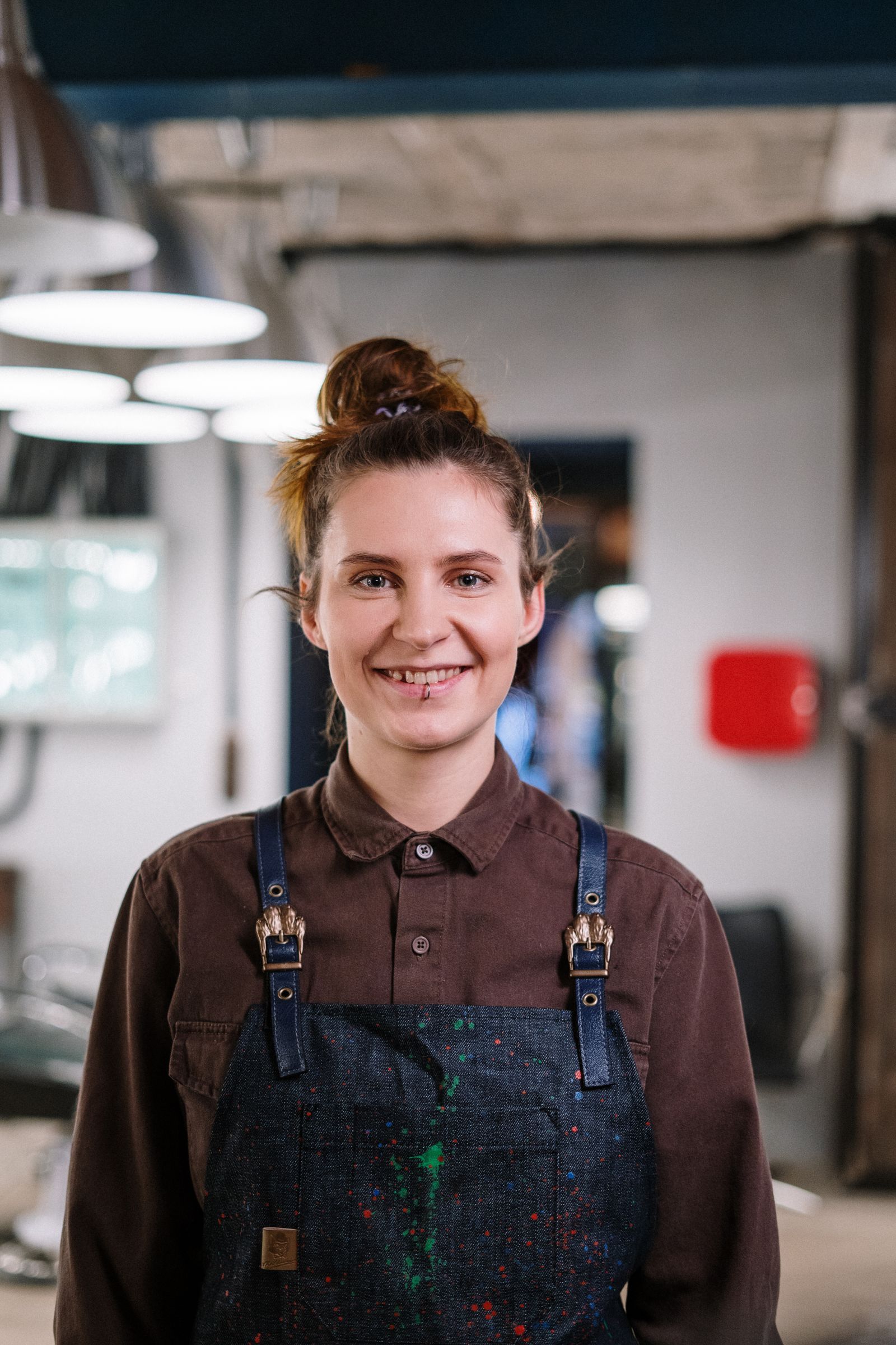 Rina Takahashi in a denim apron, smiling in the salon
