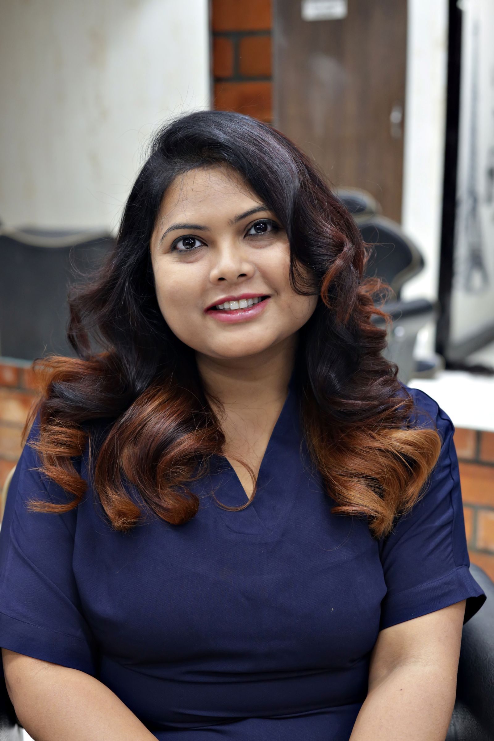 Priyanka Shah smiling, with long curled hair