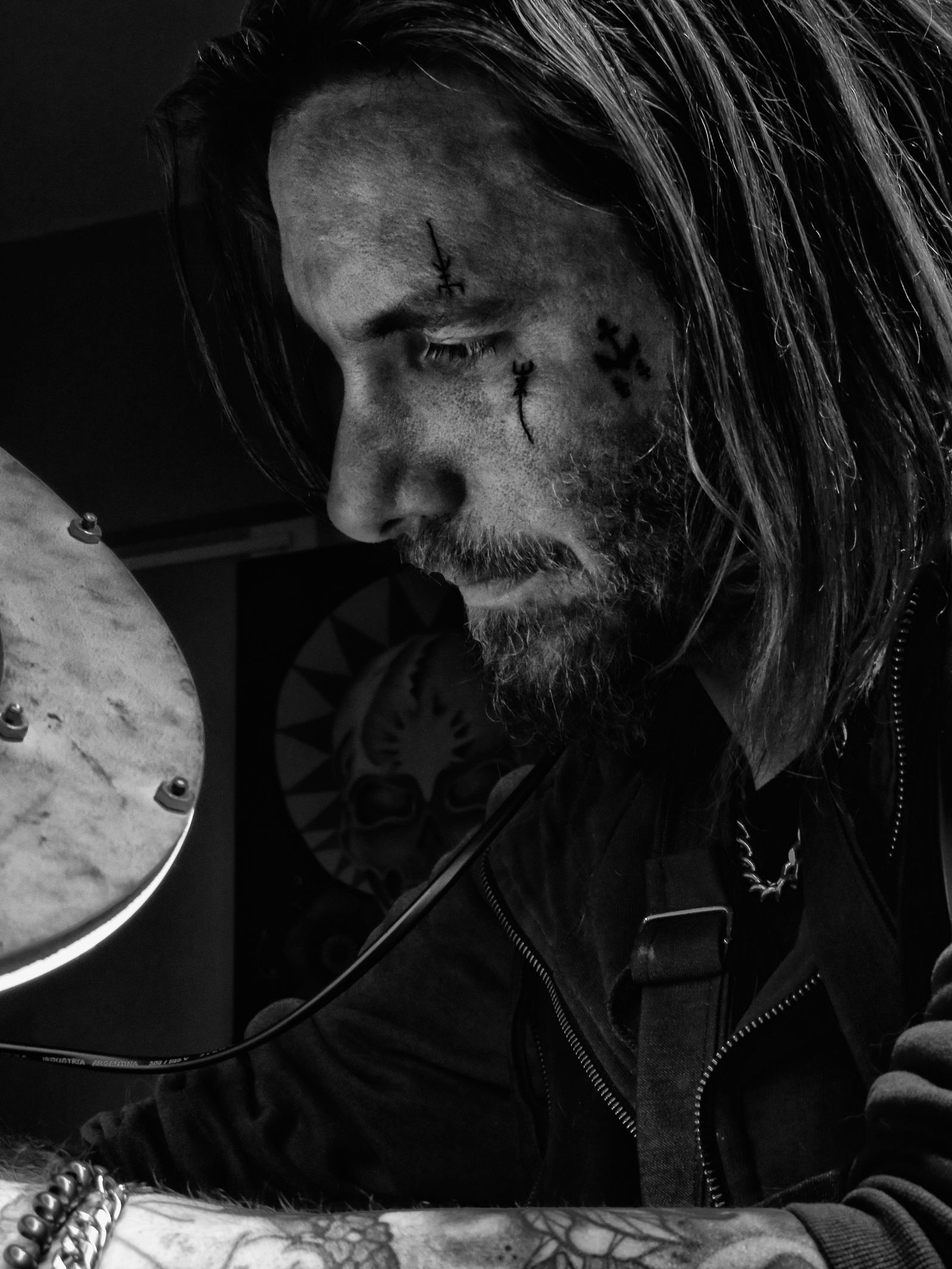 Mateo Silva in black and white, concentrating on a tattoo