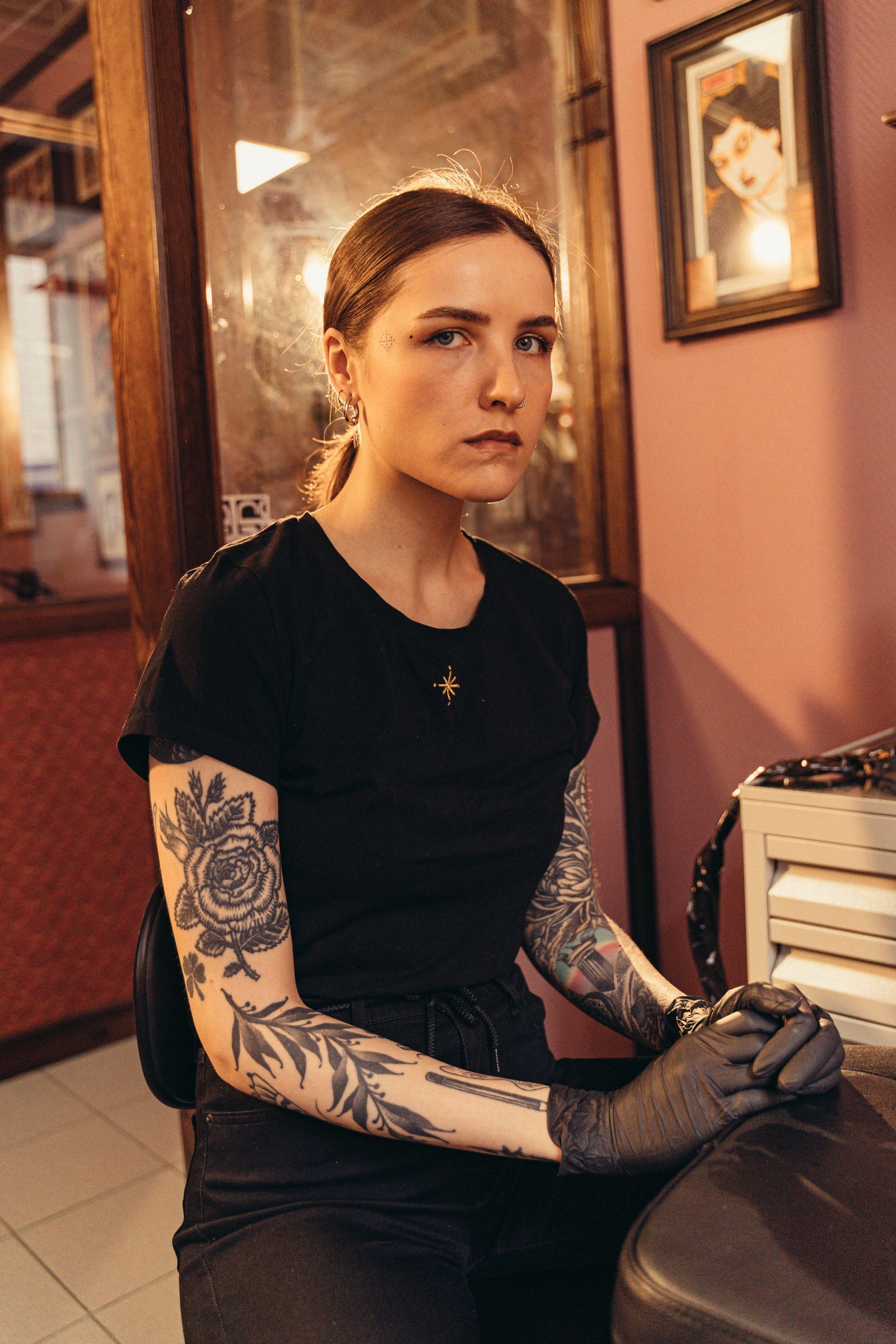 Alessa Ruiz sitting in the studio, tattooed arms crossed