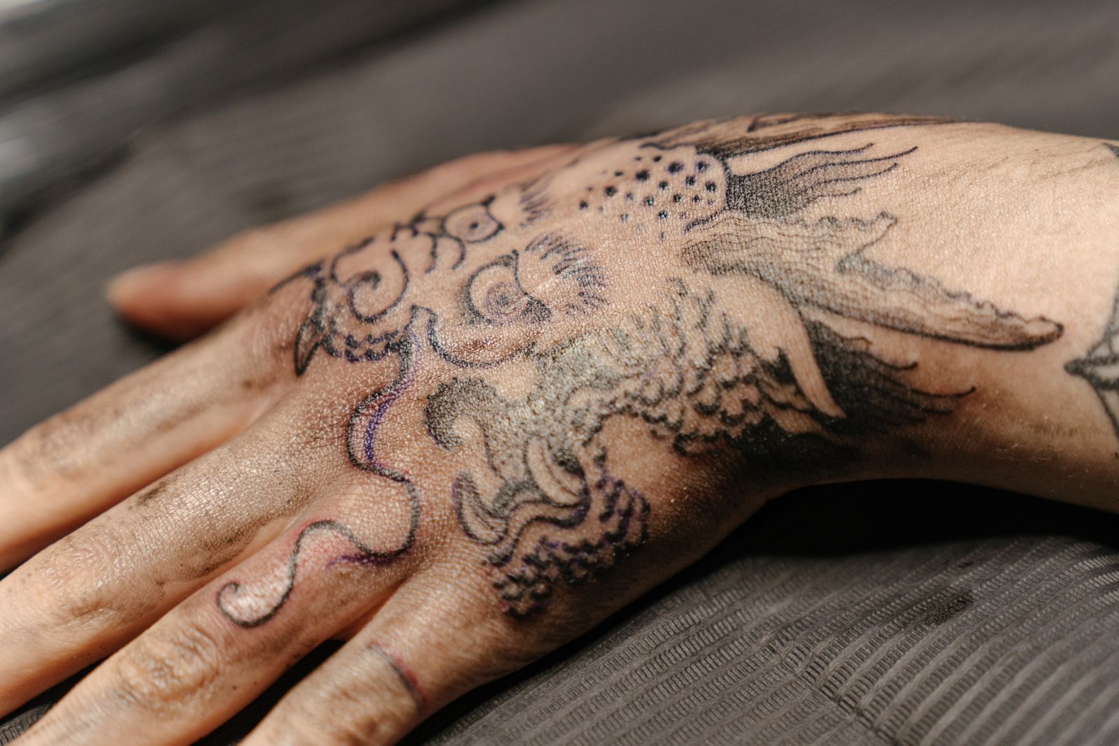 A black and grey dragon on a hand