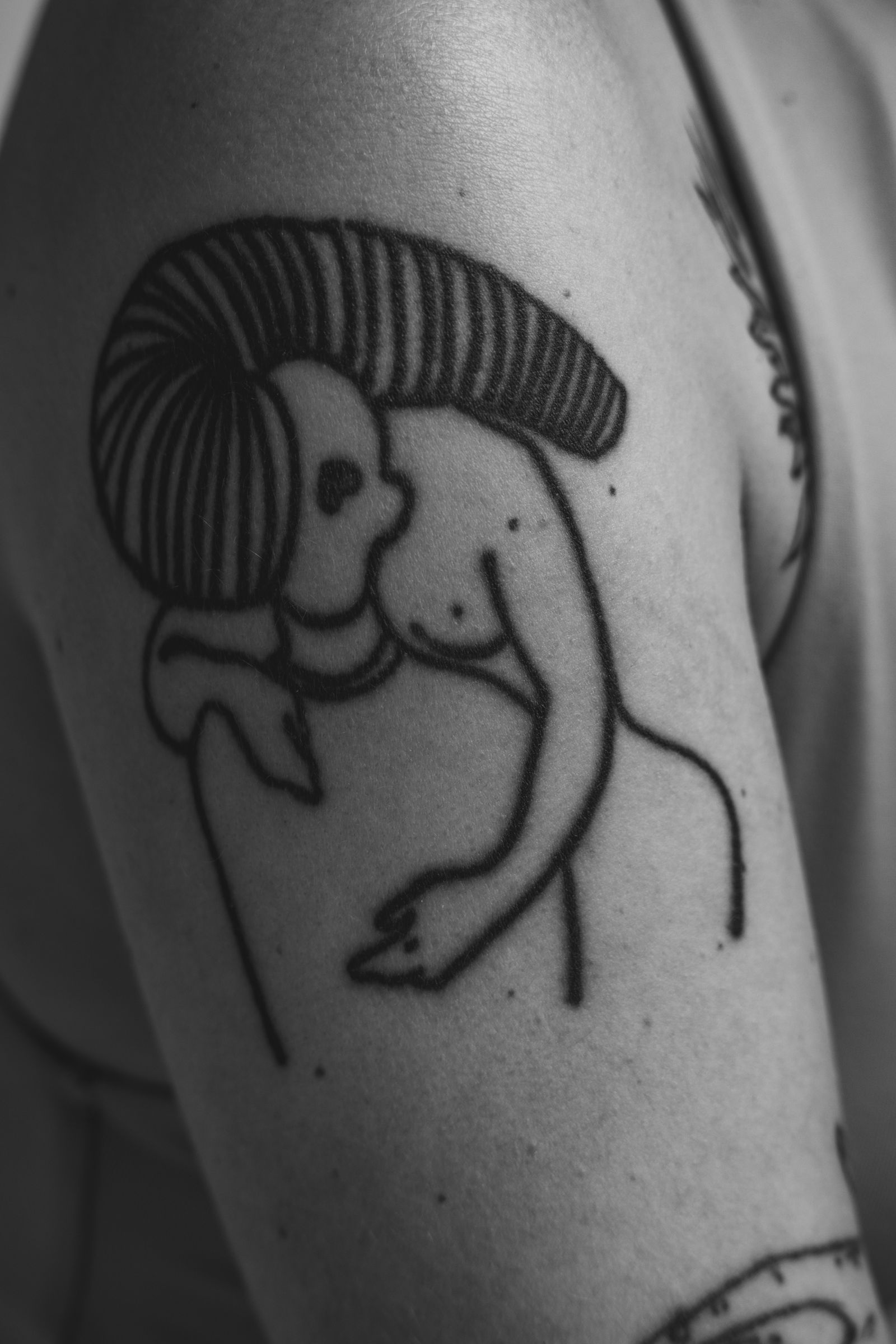 A bold blackwork figure on an upper arm
