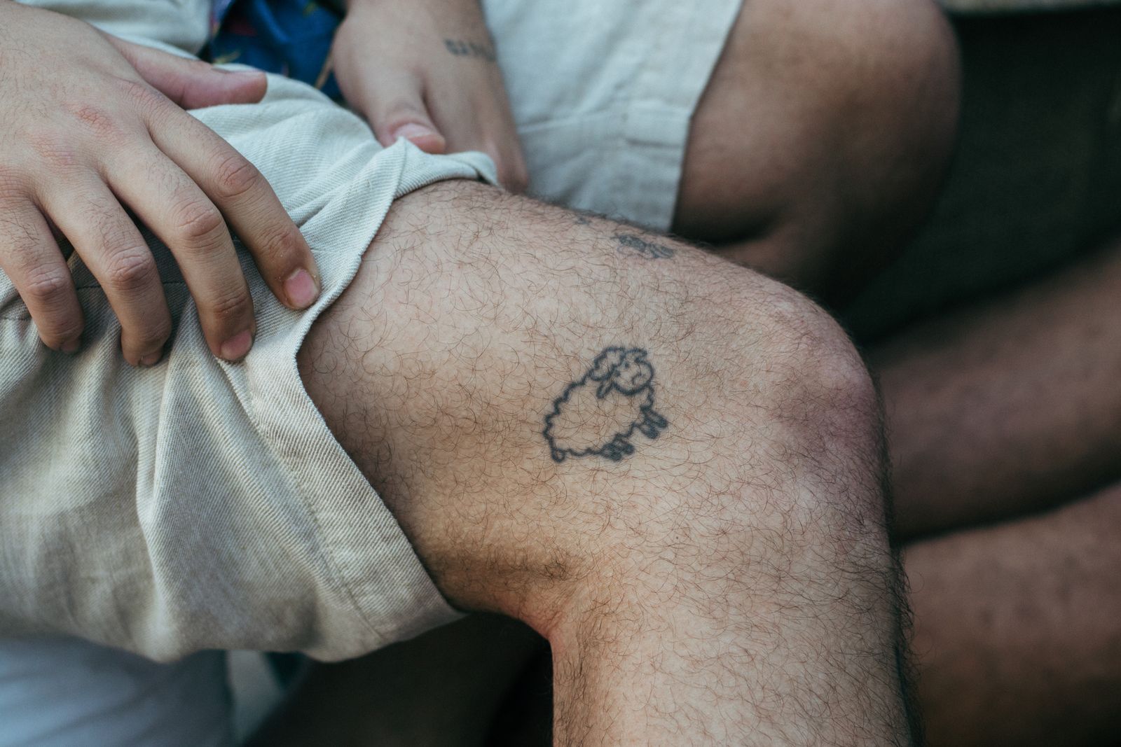 A tiny outline of a sheep on a knee