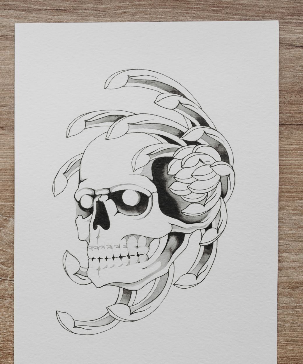 Black ink flash drawing of a skull wrapped in a peony